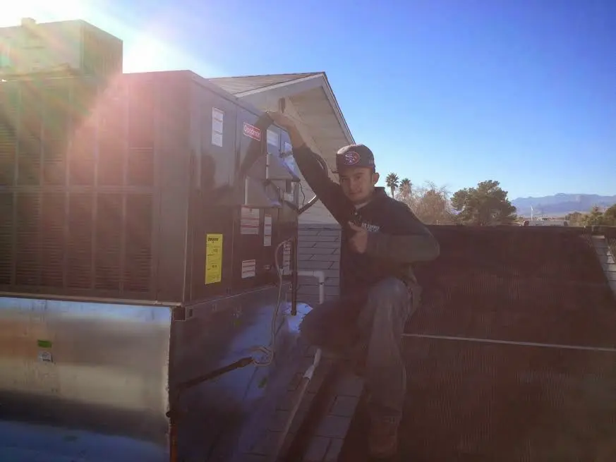 HVAC technician performing Heat Pump Repair on a rooftop unit in Lake Mills